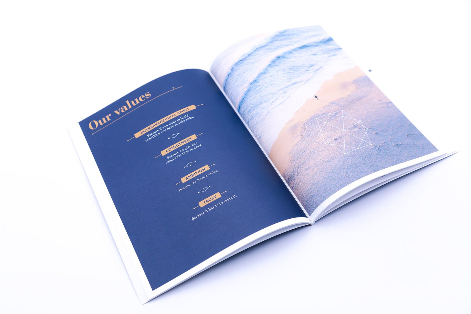 Un livret ouvert présentant une page bleue intitulée Nos valeurs avec une liste de valeurs et d'icônes, et une page photo avec une vue aérienne d'une personne marchant le long du rivage à côté de motifs géométriques dessinés dans le sable.