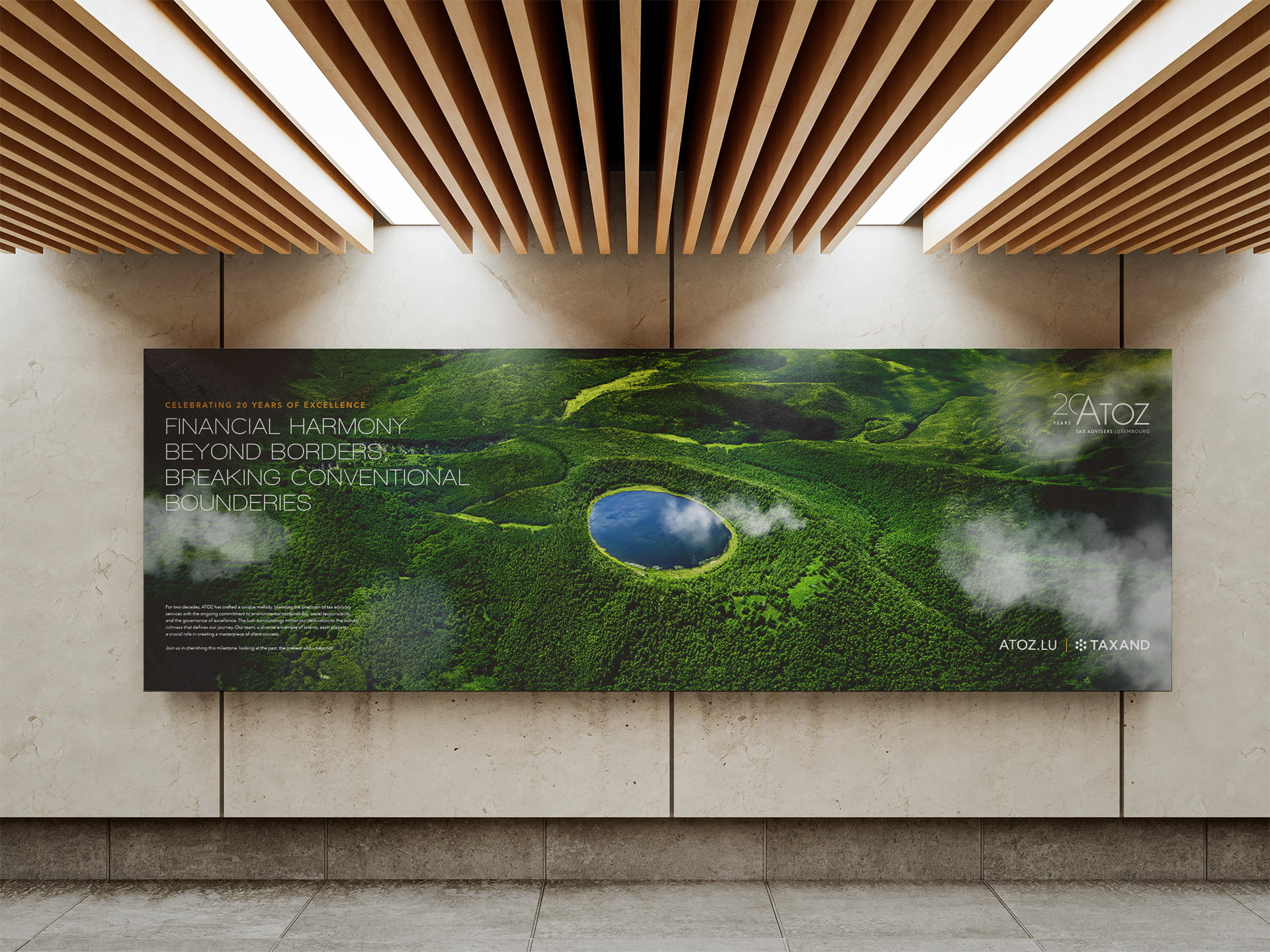 Une grande publicité murale présente une vue aérienne d'une forêt verdoyante avec un lac rond et bleu au centre. À l'occasion de ses 20 ans, Atoz promeut l'harmonie financière durable et le dépassement des limites. Des panneaux de bois modernes sont installés au plafond.