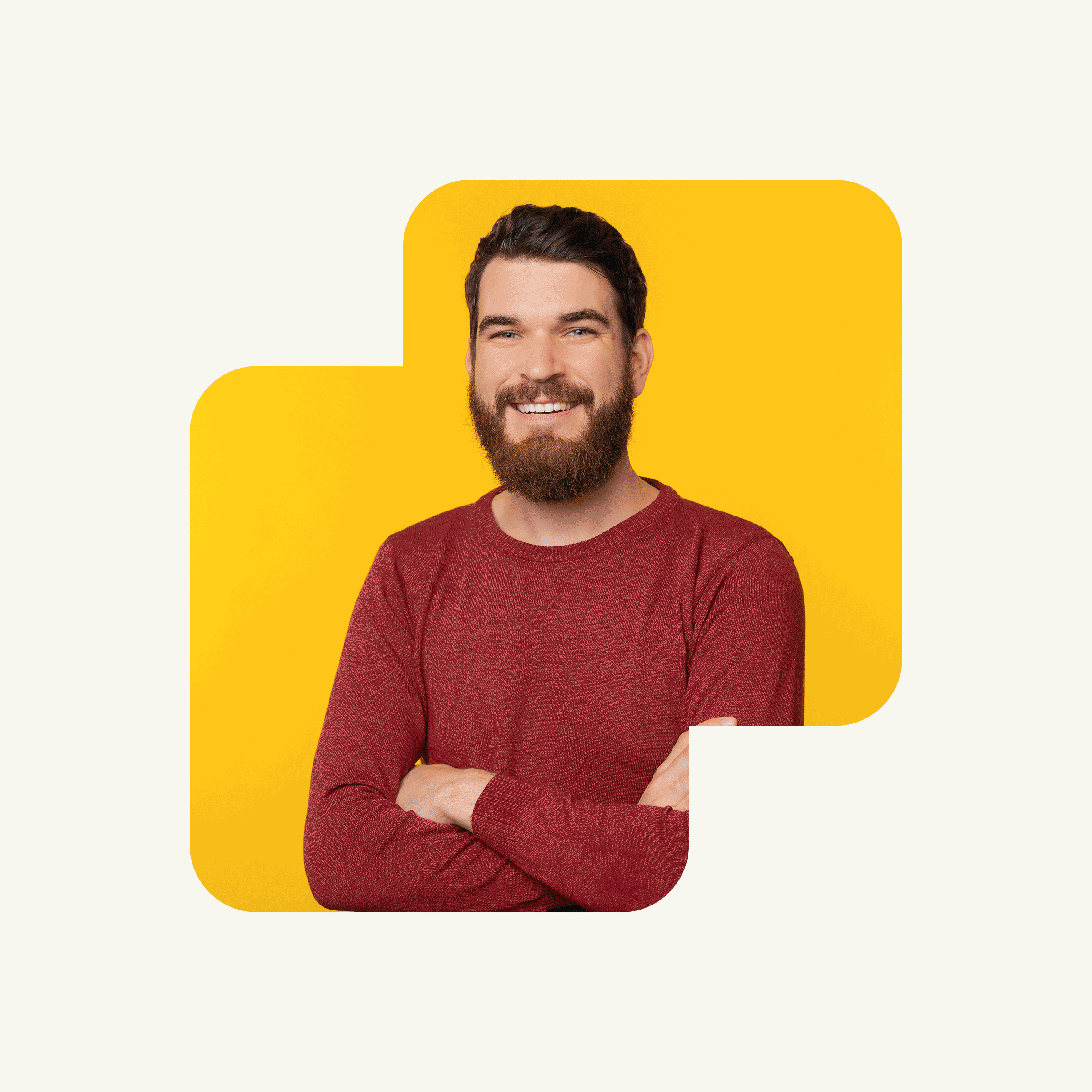 Un homme souriant, barbu et aux cheveux foncés, vêtu d'un pull-over rouge, se tient debout, les bras croisés, sur un fond jaune vif encadré de formes rectangulaires arrondies.