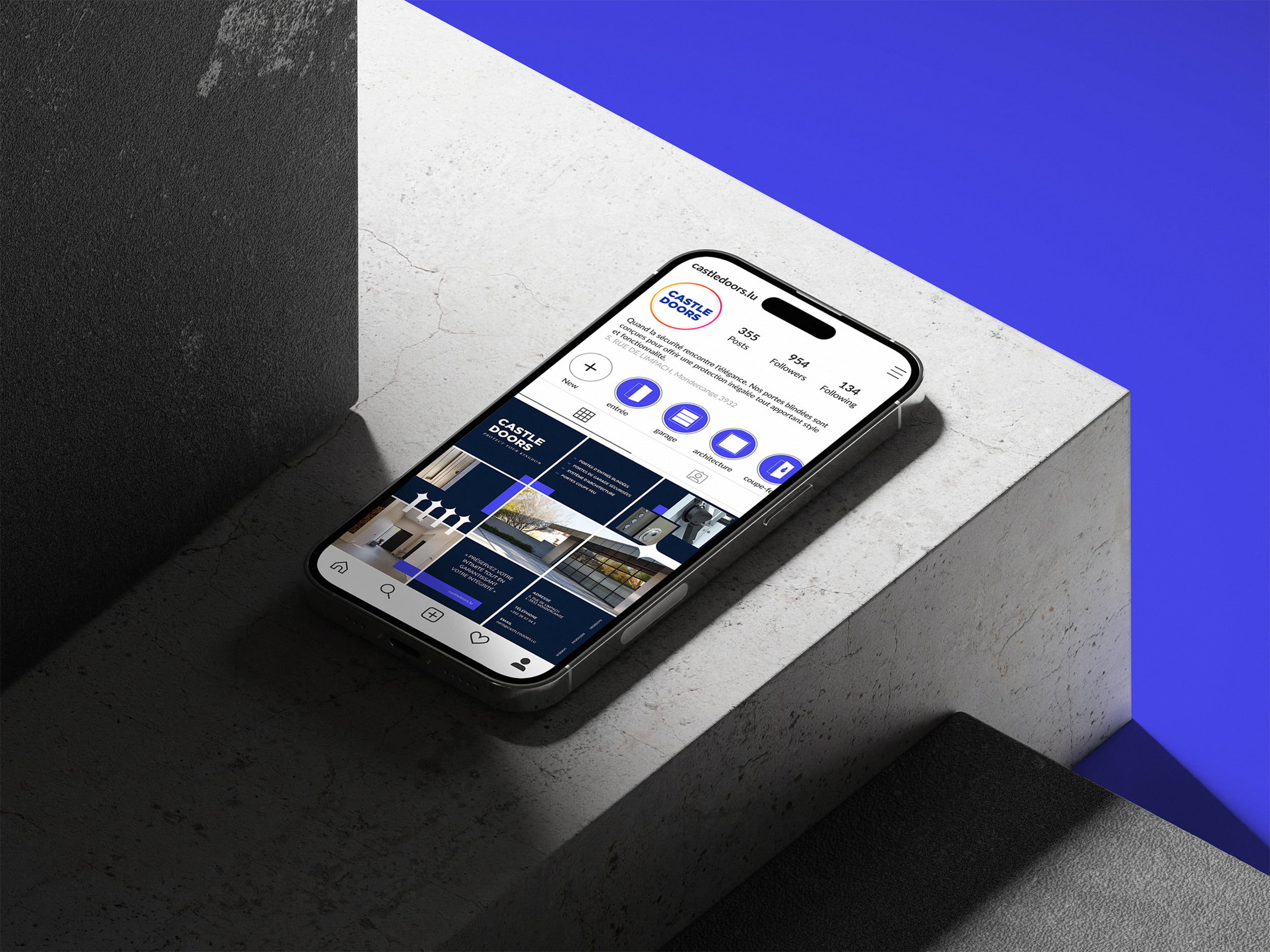 Un smartphone affichant un profil Instagram avec un thème bleu et blanc repose sur une surface en béton, avec un fond violet lumineux éclairant une partie de la scène.