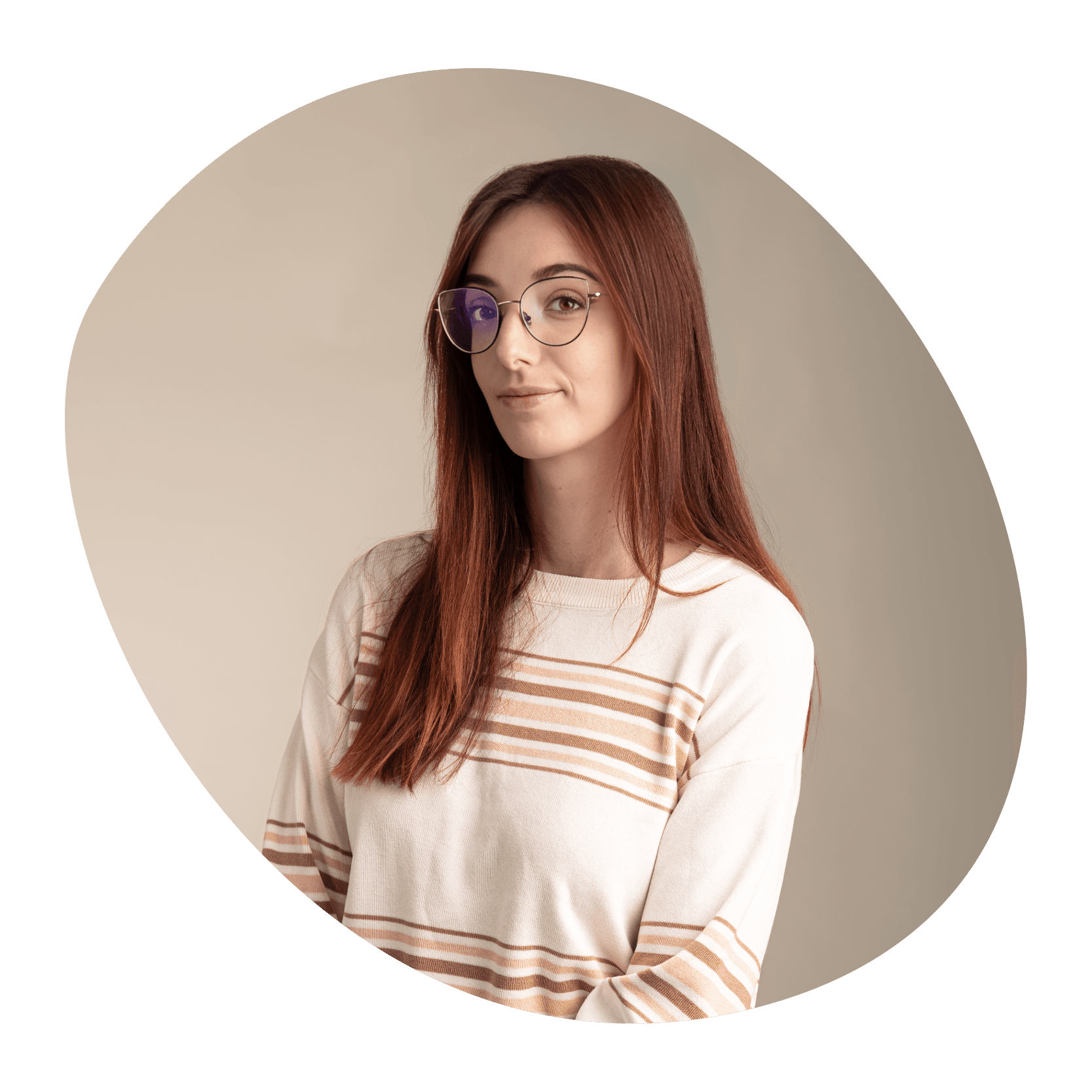 Une jeune femme aux longs cheveux bruns et aux lunettes, portant un pull crème à rayures beiges, se tient debout sur un fond beige, regardant l'appareil photo avec une expression neutre.