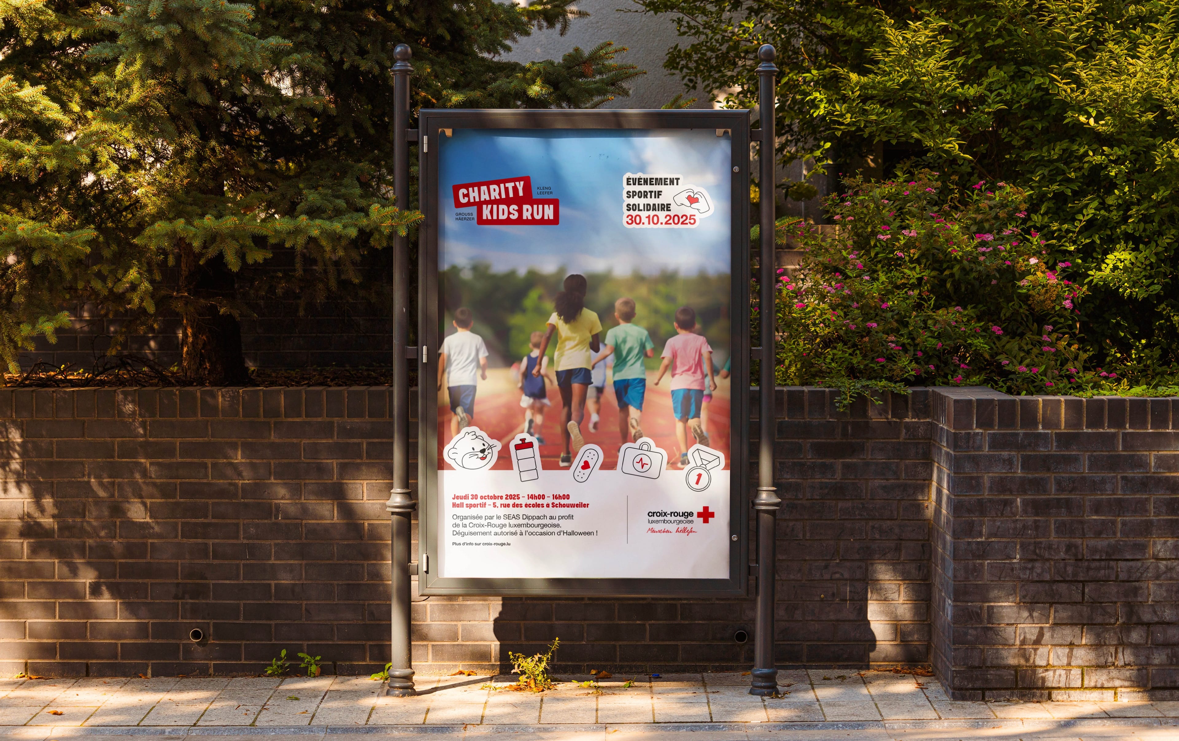 Panneau d'affichage urbain présentant l'affiche Charity Kids Run du 30 octobre 2025 : des enfants courent sur une piste, entourés des pictogrammes de l'événement.